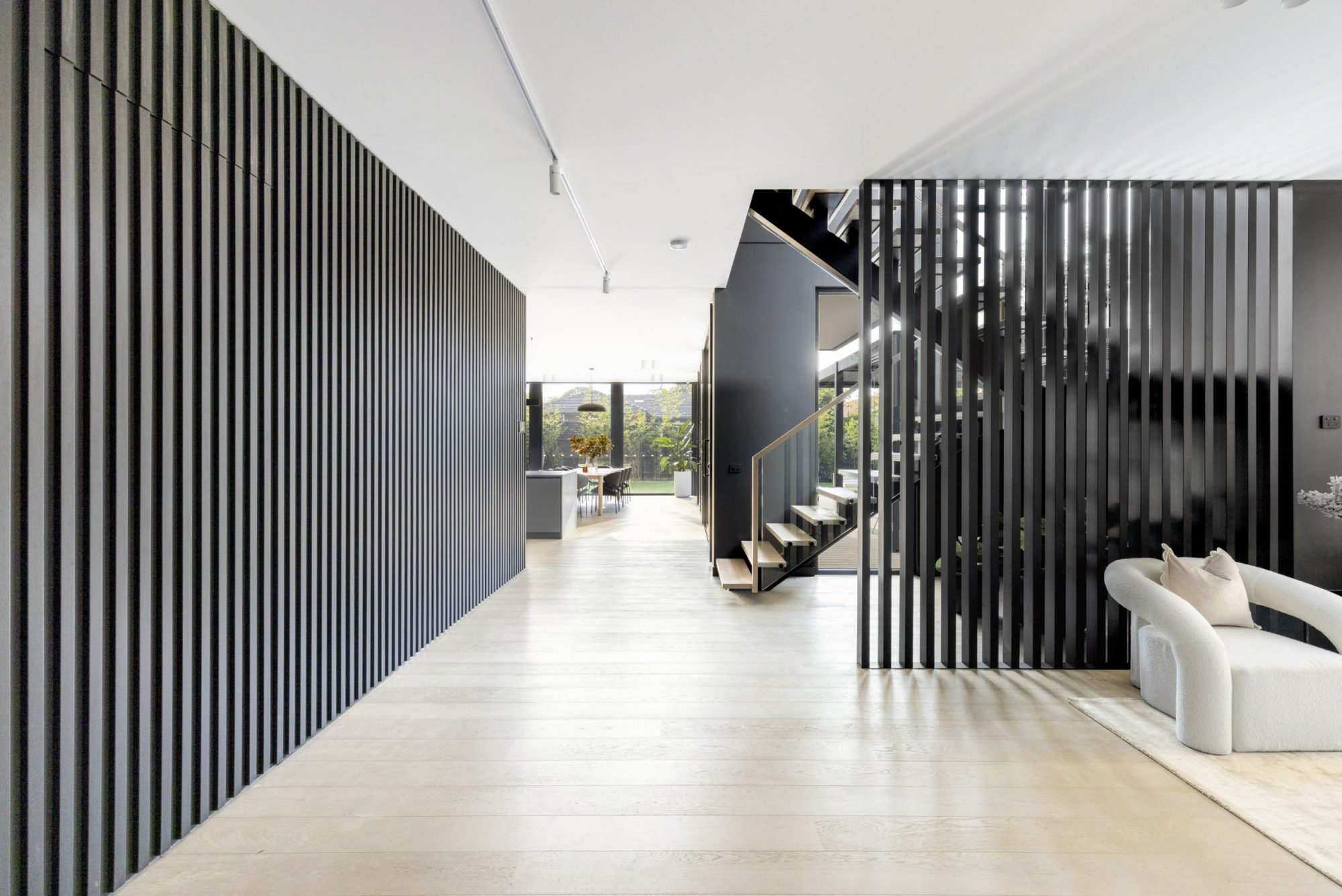 Entry hallway with black vertical battens and staircase, Scheele Residence Surrey Hills